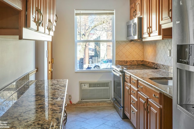 26-08 24th Ave, New York City, NY 11102 - kitchen featuring stainless steel appliances, brown cabinetry, tasteful backsplash, a wall unit AC, and a sink