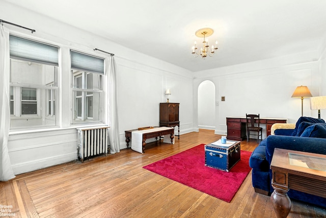 45-14 43rd St Unit 2D, New York City, NY 11104 - living room featuring radiator, arched walkways, a chandelier, and wood finished floors