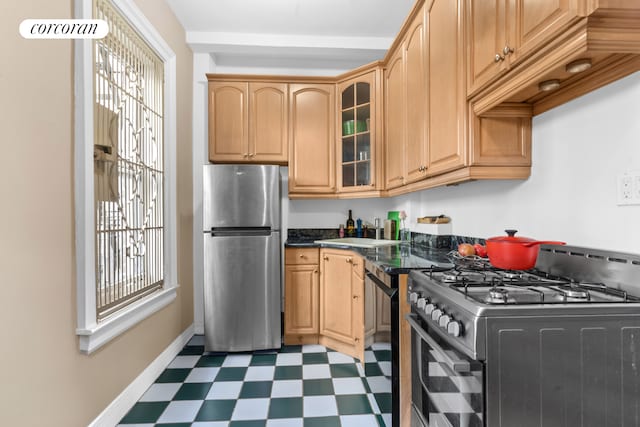 25 W 64th St Unit 2E, New York City, NY 10023 - kitchen with appliances with stainless steel finishes, tile patterned floors, glass insert cabinets, a sink, and baseboards