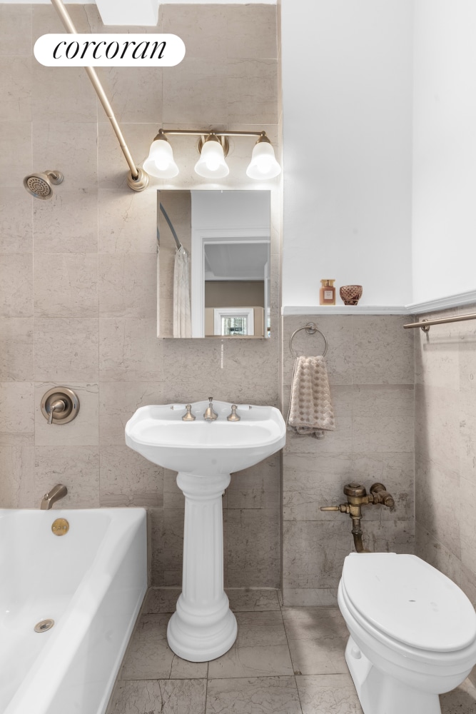 25 W 64th St Unit 2E, New York City, NY 10023 - full bathroom featuring tile walls, bathing tub / shower combination, and toilet