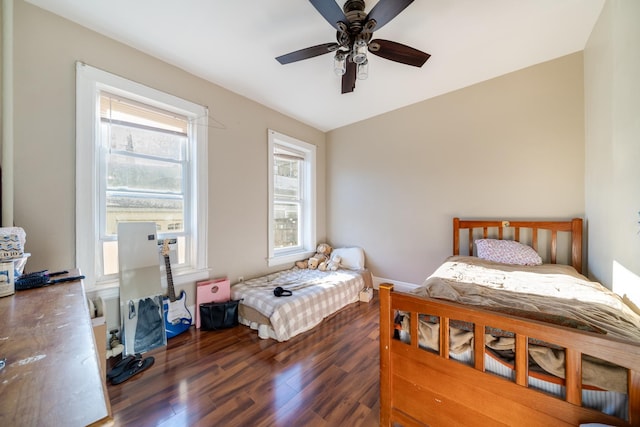 bedroom with wood finished floors, multiple windows, and ceiling fan
