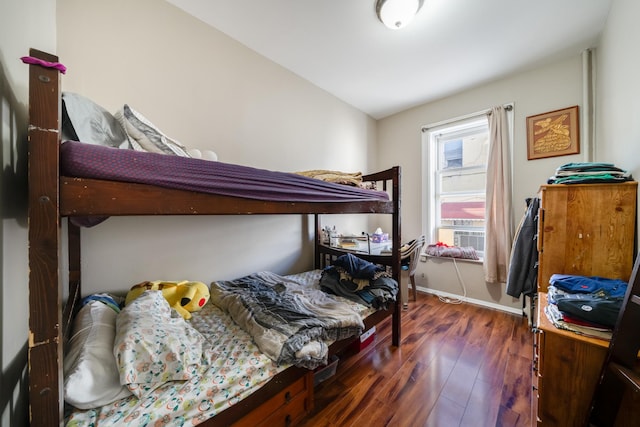 bedroom with wood finished floors, baseboards, and cooling unit