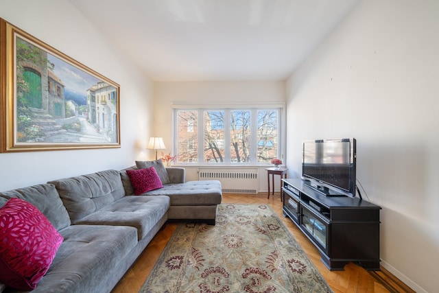 living room featuring radiator, light wood-style floors, and baseboards