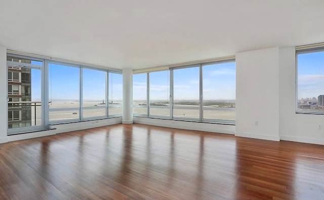 30 W St Unit 20F, New York City, NY 10004 - spare room with wood finished floors, baseboards, and a baseboard radiator