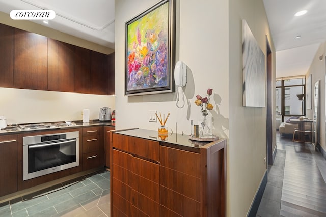 40 Broad St Unit 18C, New York City, NY 10004 - kitchen featuring modern cabinets, stainless steel appliances, dark tile patterned flooring, and recessed lighting