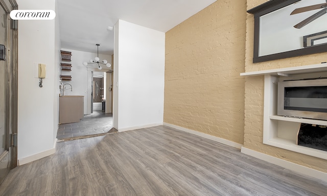107 W 106th St Unit A, New York City, NY 10025 - unfurnished living room with wood finished floors, ceiling fan, baseboards, a chandelier, and a textured wall