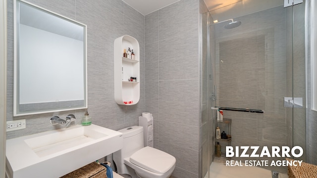 302 E 96th St Unit 502, New York City, NY 10128 - bathroom featuring tile walls, a tile shower, toilet, and a sink