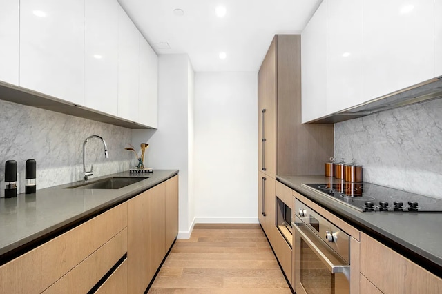 302 E 96th St Unit 502, New York City, NY 10128 - kitchen with a sink, stainless steel oven, modern cabinets, black electric cooktop, and recessed lighting