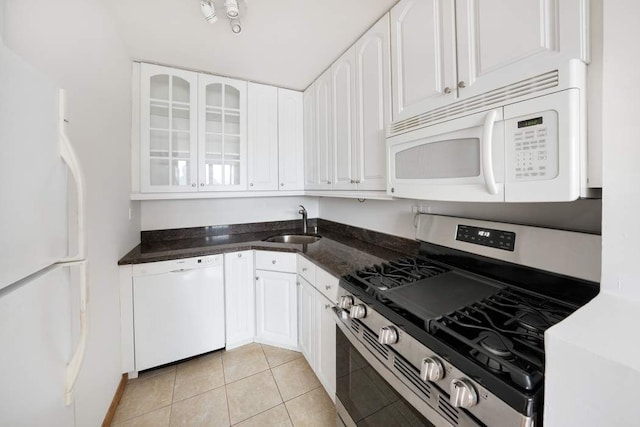 kitchen with white appliances, a sink, white cabinetry, and glass insert cabinets