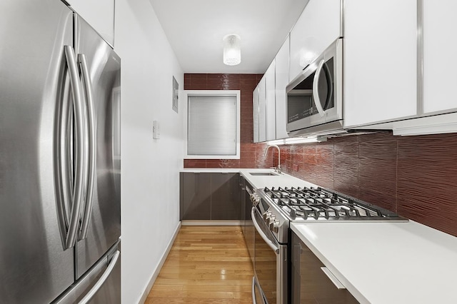 310 E 49th St Unit 4-D, New York City, NY 10017 - kitchen featuring stainless steel appliances, modern cabinets, light countertops, light wood-style flooring, and white cabinetry