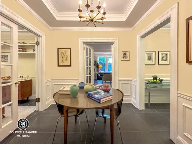 51 E 90th St Unit 1C, New York City, NY 10128 - dining room featuring dark tile patterned floors, a chandelier, a tray ceiling, a wainscoted wall, and ornamental molding