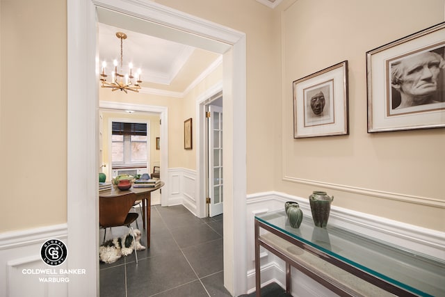 51 E 90th St Unit 1C, New York City, NY 10128 - hallway with a chandelier, ornamental molding, a decorative wall, a wainscoted wall, and dark tile patterned floors