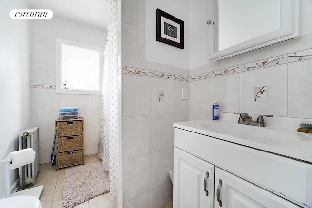 full bath with radiator heating unit, tile walls, vanity, a shower with shower curtain, and tile patterned floors