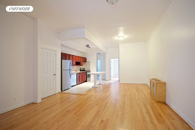 unfurnished living room with light wood-type flooring, ornamental molding, and baseboards