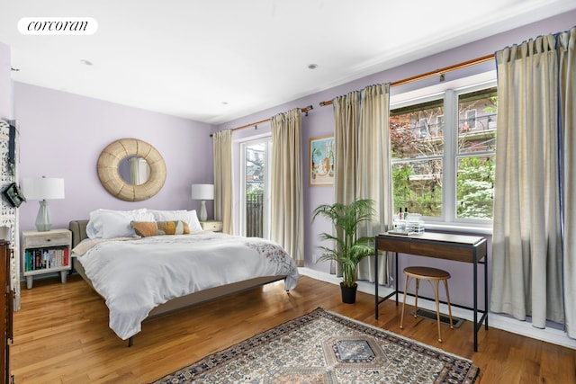 bedroom with wood finished floors and baseboards