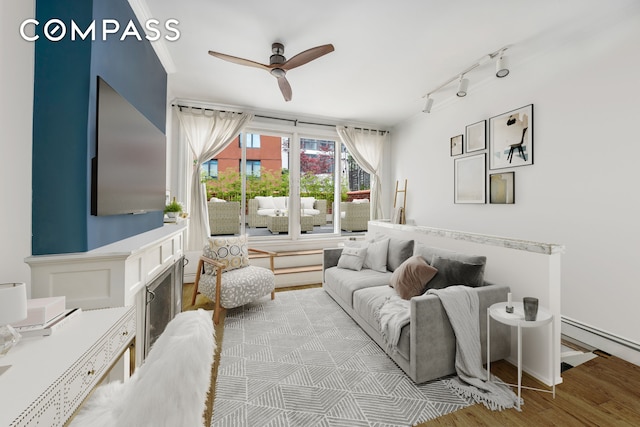 255 W 95th St Unit 6D, New York City, NY 10025 - living area with track lighting, ceiling fan, wood finished floors, and a baseboard radiator