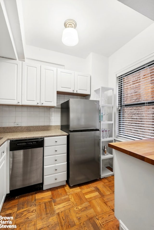 123 E 37th St Unit 6B, New York City, NY 10016 - kitchen with stainless steel appliances, decorative backsplash, white cabinets, and butcher block counters
