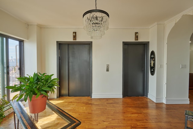 75 Livingston St Unit 28-A, New York City, NY 11201 - dining space featuring arched walkways, wood finished floors, elevator, a chandelier, and crown molding