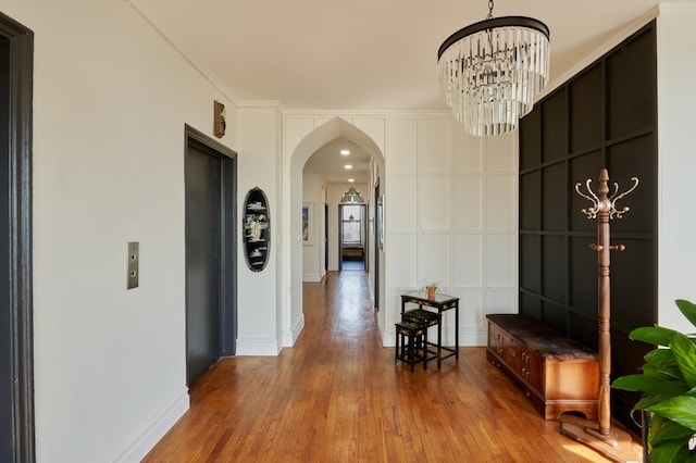 75 Livingston St Unit 28-A, New York City, NY 11201 - corridor with arched walkways, hardwood / wood-style floors, a decorative wall, a chandelier, and crown molding