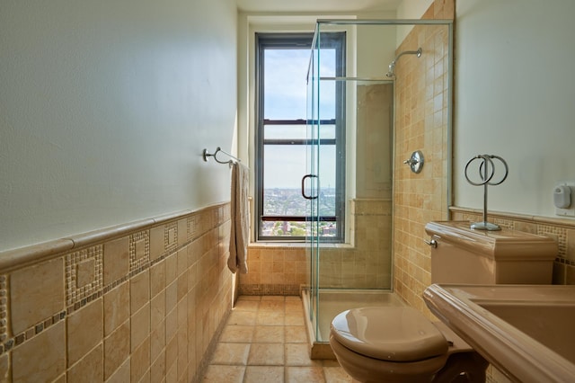75 Livingston St Unit 28-A, New York City, NY 11201 - full bath featuring tile walls, a stall shower, stone tile floors, and a wainscoted wall