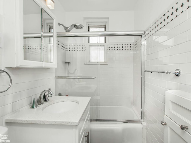 5639 Netherland Ave Unit 5C, New York City, NY 10471 - bathroom featuring tile walls, shower / bath combination with glass door, and vanity