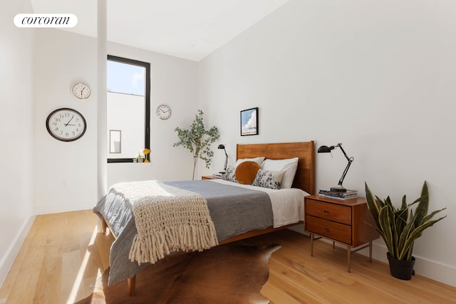 bedroom with light wood-style floors and baseboards