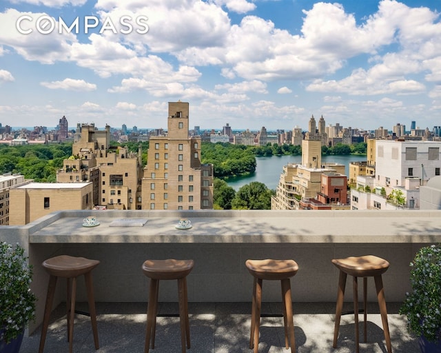 balcony with a skyline view and a water view