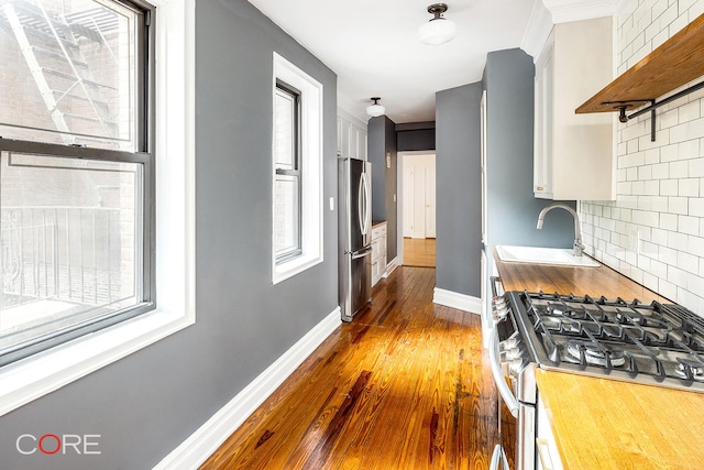 35-15 84th St Unit 2E, New York City, NY 11372 - kitchen featuring a sink, appliances with stainless steel finishes, open shelves, and plenty of natural light