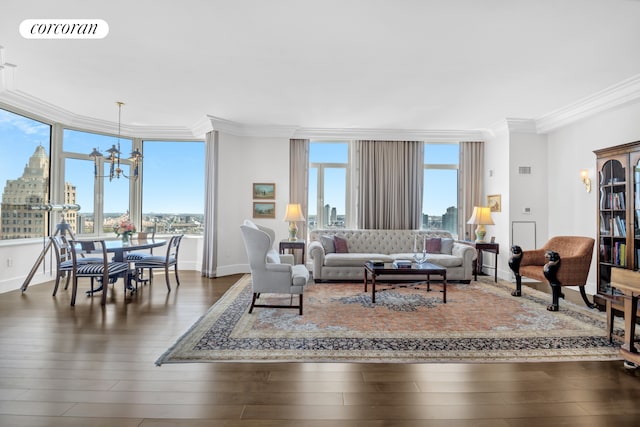 living area featuring crown molding, a chandelier, hardwood / wood-style floors, a skyline view, and baseboards
