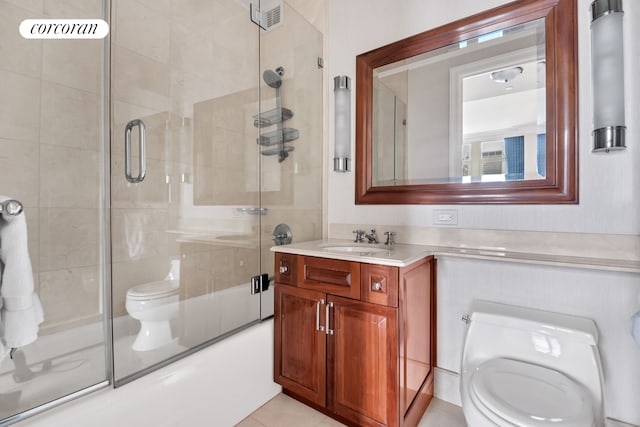 bathroom with toilet, vanity, and combined bath / shower with glass door