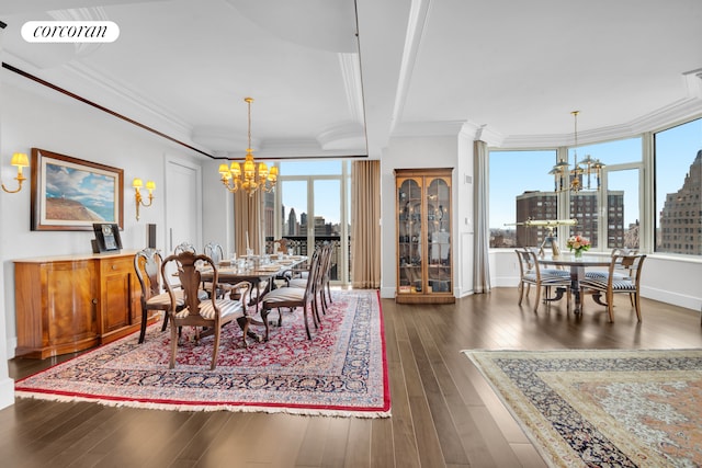 dining room with a chandelier, dark wood-type flooring, a view of city, crown molding, and baseboards
