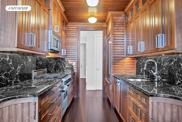kitchen with stainless steel appliances, brown cabinets, tasteful backsplash, a sink, and wood ceiling
