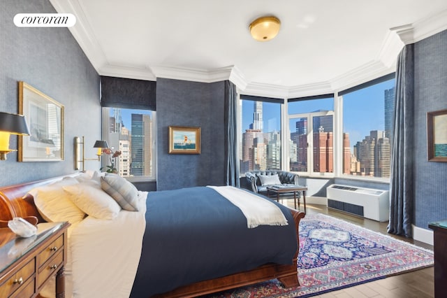 bedroom with crown molding, wood finished floors, and a skyline view