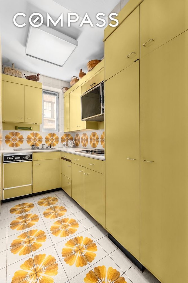575 Park Ave Unit 608/609, New York City, NY 10065 - kitchen with dishwashing machine, stainless steel microwave, light countertops, and cream cabinetry