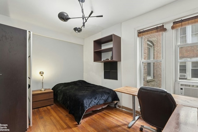 128 W 138th St Unit 3H, New York City, NY 10030 - bedroom featuring wood finished floors, a chandelier, and cooling unit