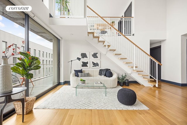 123 Clinton Ave Unit 4B, New York City, NY 11205 - living area with a high ceiling, wood finished floors, stairway, and baseboards