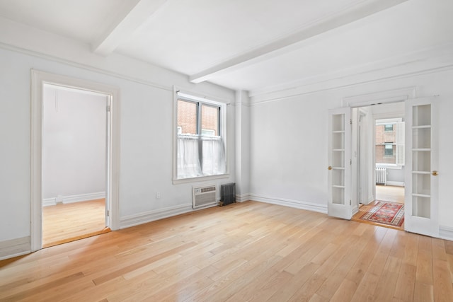 345 W 55th St Unit 9-Gh, New York City, NY 10019 - spare room featuring french doors, beamed ceiling, healthy amount of natural light, light wood finished floors, and a wall mounted AC