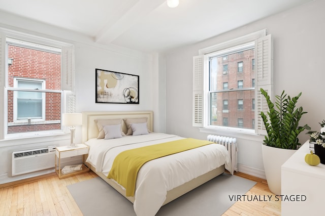 345 W 55th St Unit 9-Gh, New York City, NY 10019 - bedroom with radiator, beamed ceiling, hardwood / wood-style floors, and an AC wall unit