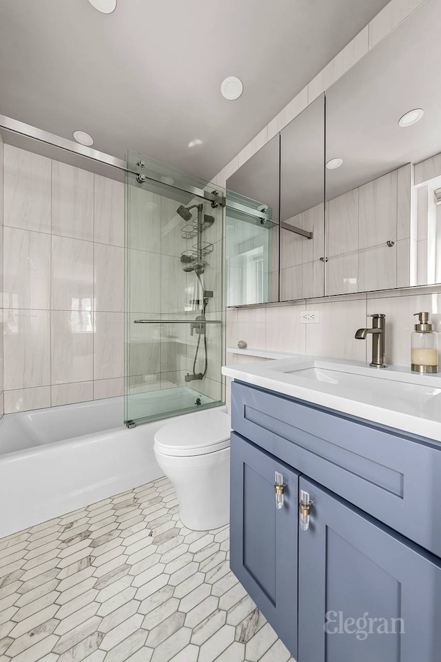 166 E 63rd St Unit 20A, New York City, NY 10065 - bathroom with toilet, bath / shower combo with glass door, vanity, tile walls, and recessed lighting
