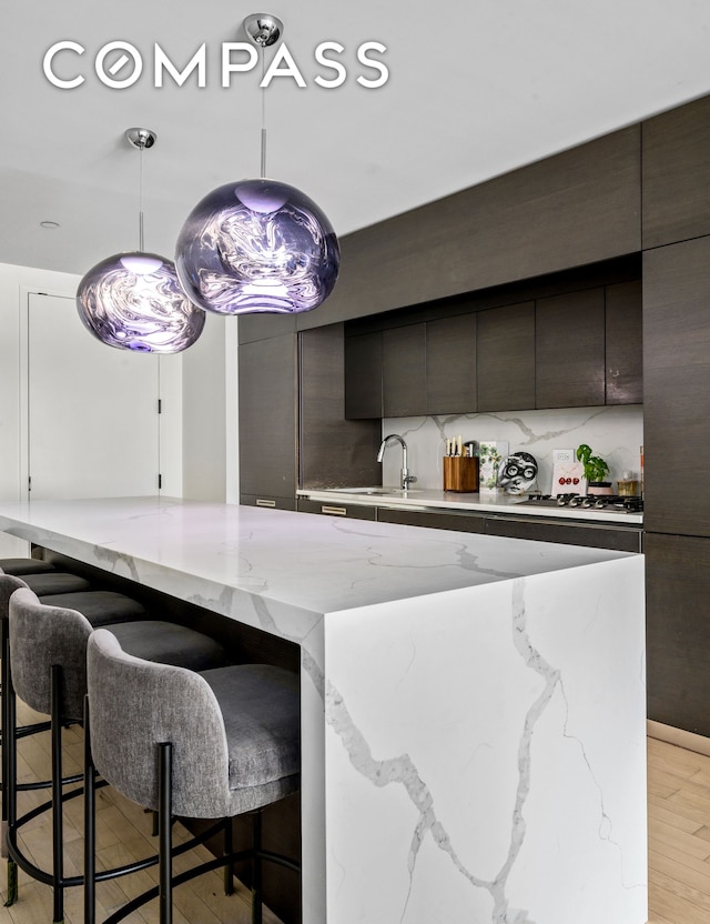 20 Pine St Unit 1201, New York City, NY 10005 - kitchen featuring a kitchen breakfast bar, modern cabinets, a spacious island, and light wood finished floors