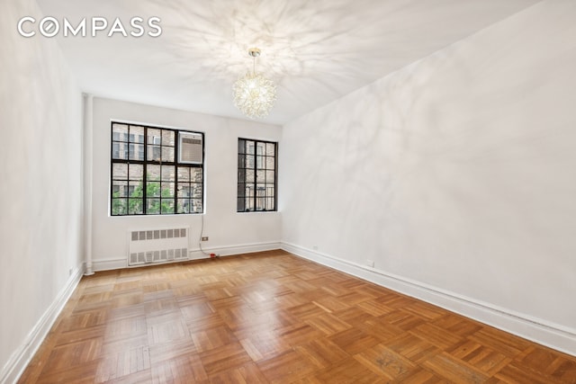 116 Pinehurst Ave Unit H32, New York City, NY 10033 - spare room with radiator heating unit, a chandelier, and baseboards