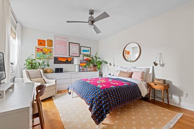 bedroom with wood finished floors, baseboards, and ceiling fan
