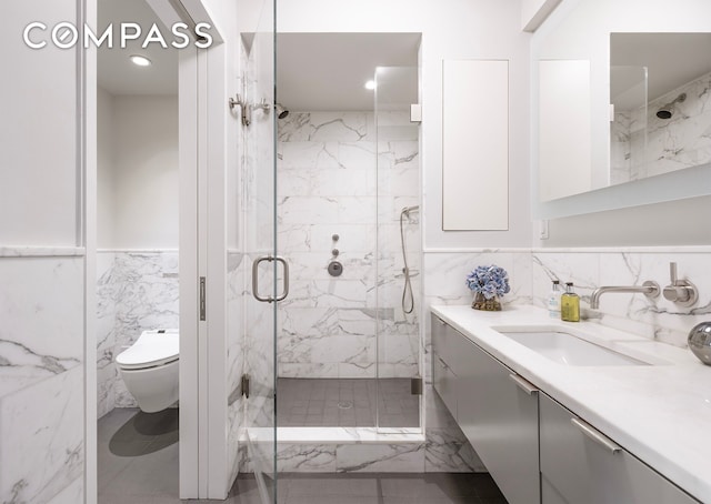45 E 72nd St Unit 9Bc, New York City, NY 10021 - bathroom featuring tile walls, a marble finish shower, vanity, toilet, and wainscoting