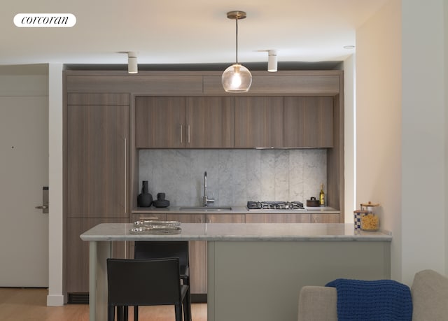 234 E 46th St Unit 1505, New York City, NY 10017 - kitchen with a sink, decorative backsplash, a kitchen breakfast bar, and modern cabinets