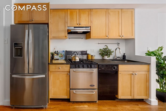 569 Carroll St Unit 9, New York City, NY 11215 - kitchen with appliances with stainless steel finishes, under cabinet range hood, a sink, dark countertops, and wood finished floors