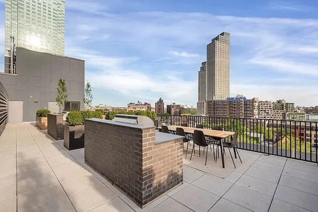 21-30 44th Dr Unit 7C, New York City, NY 11101 - view of patio featuring an outdoor kitchen and a city view