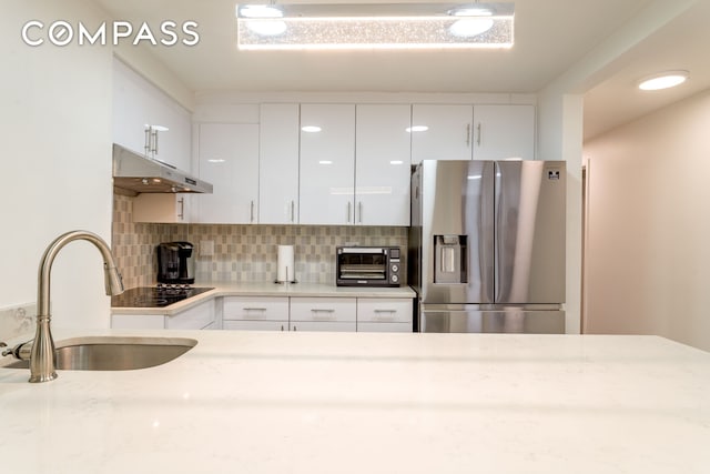 212 E 70th St Unit B, New York City, NY 10021 - kitchen featuring stainless steel fridge with ice dispenser, under cabinet range hood, black electric cooktop, and white cabinets