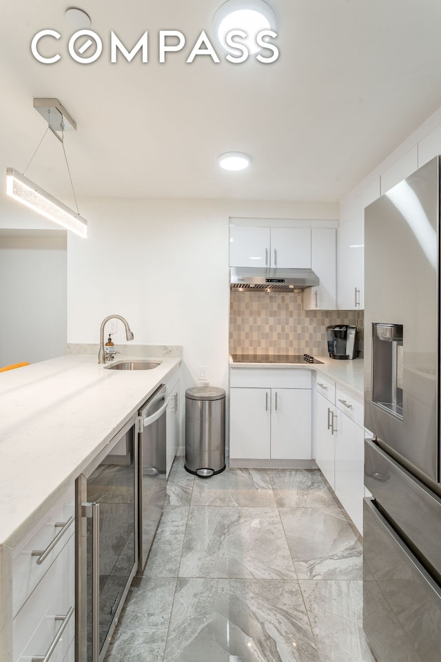 212 E 70th St Unit B, New York City, NY 10021 - kitchen featuring stainless steel appliances, beverage cooler, light countertops, white cabinets, and light marble finish flooring