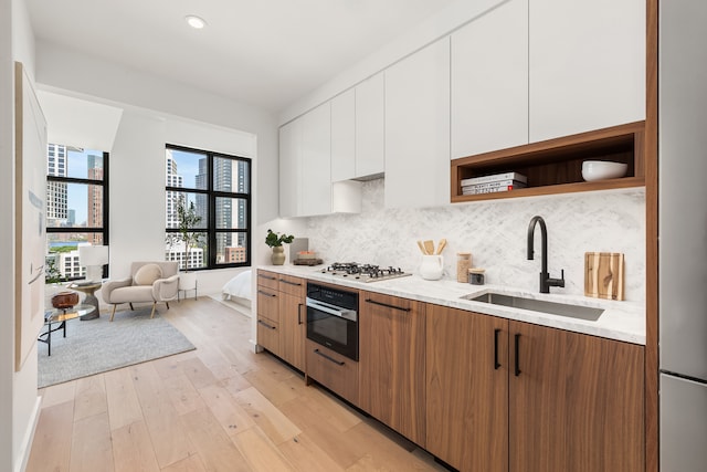 29 Huron St Unit 10Ae, New York City, NY 11222 - kitchen with black oven, open shelves, stainless steel gas stovetop, modern cabinets, and white cabinetry