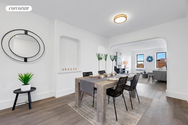 3000 Valentine Ave Unit 2B, New York City, NY 10458 - dining space featuring arched walkways, wood finished floors, and baseboards